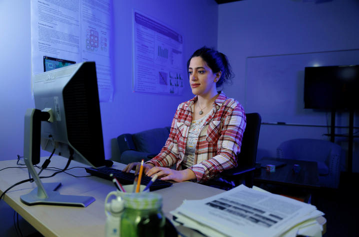 Student sitting at desk typing on computer 