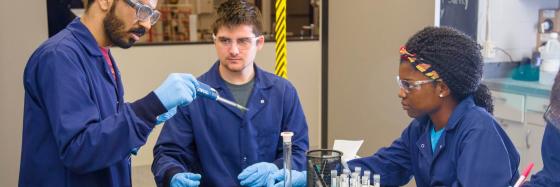 Student working on machines surrounded by toolboxes in an lab.
